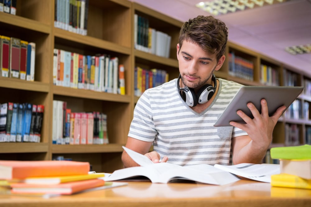 Student studying in the library with tablet at the university