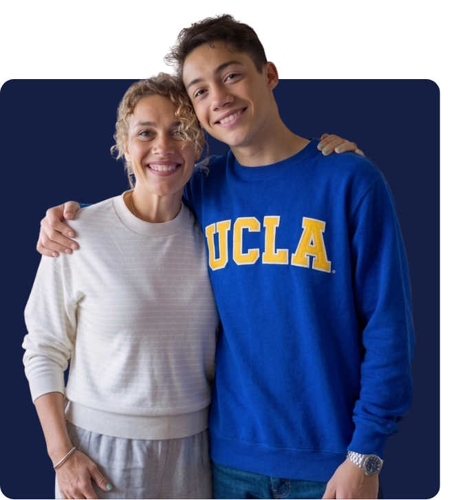 Student smiling and posing with mother in a blue UCLA sweatshirt